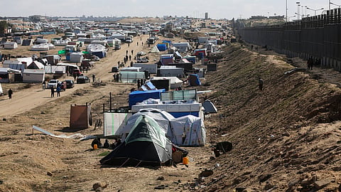 Palestinians displaced by the Israel air and ground offensive on the Gaza Striptake shelter near the border fence with Egypt in Rafah, Wednesday, Jan. 24, 2024.