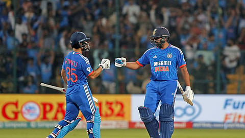 Rinku Singh and captain Rohit Sharma touch gloves during the third T20 cricket match between Afghanistan and India in Bengaluru.