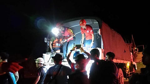 Philippine Red Cross, volunteers assists residents evacuate to safer grounds following a landslide at their village at Maco, Davao de Oro province, south Philippines.