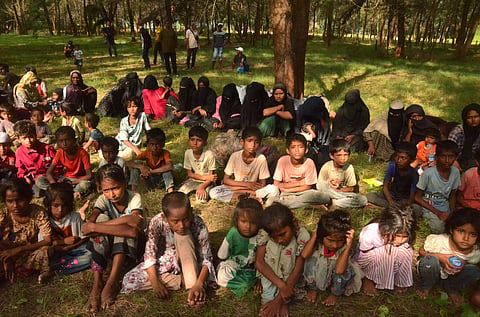 Ethnic Rohingya people sit on a beach after they land in Kuala Parek Beach, East Aceh, Aceh province, Indonesia, Thursday, Feb. 1, 2024.