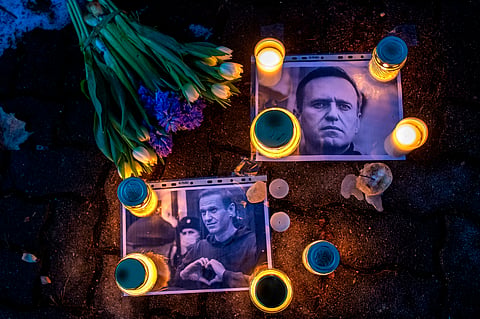Photos of Russian opposition leader Alexei Navalny, with flowers and candles are laid on a ground in front of the Russian embassy.