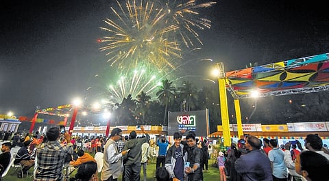 Revellers watch a firecrackers show on the opening day of Ekamra Utsav at exhibition ground in Bhubaneswar on Saturday