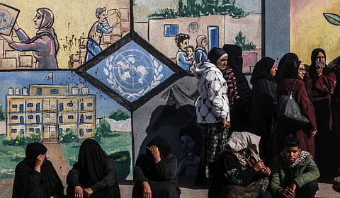 Displaced Palestinians queue to receive aid in front of the United Nations Relief and Works Agency for Palestine Refugees (UNRWA) centre in Rafah in the southern Gaza Strip on January 28, 2024