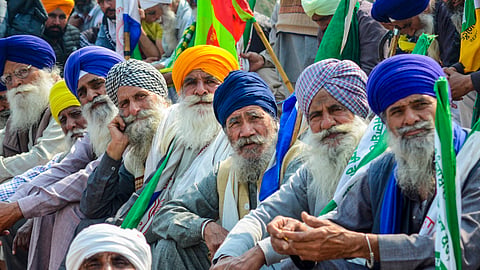 Farmers listen to a leader (unseen) at the Punjab-Haryana Shambhu border during farmers' 'Delhi Chalo' protest, near Patiala district, Saturday, Feb. 17, 2024.