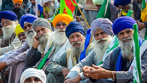 Farmers listen to a leader (unseen) at the Punjab-Haryana Shambhu border during farmers' 'Delhi Chalo' protest, near Patiala district, Saturday, Feb. 17, 2024.