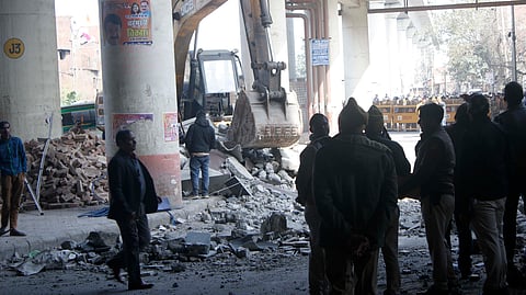 Officials stand near debris after a portion of the Gokulpuri Metro Station on the Pink Line collapsed, in New Delhi, on February 8, 2024.