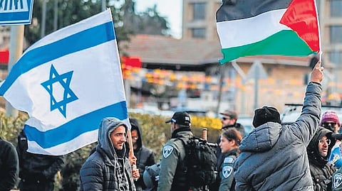 People holding Israel and Palestine flags in East Jerusalem