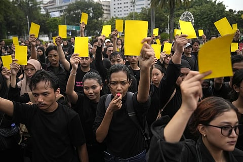 Activists hold yellow cards to symbolize a warning for Jokowi Widodo who faces mounting criticism over his lack of neutrality in the Feb 14 presidential election after he threw his support behind frontrunner Prabowo Subianto , Thursday, Feb 15, 2024.