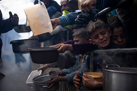 Palestinians line up for a free meal in Rafah, Gaza Strip.