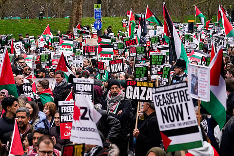 Protesters hold up flags and placards during a demonstration in support of Palestinian people in Gaza, in London, Saturday, Feb. 17, 2024.