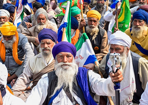 Farmers listen to a leader at the Punjab-Haryana Shambhu border during their 'Delhi Chalo' protest, near Patiala district, Monday, Feb. 19, 2024.