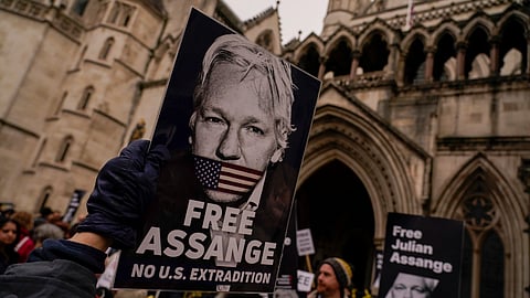 Demonstrators hold banners outside the Royal Courts of Justice in London, Tuesday, Feb. 20, 2024.