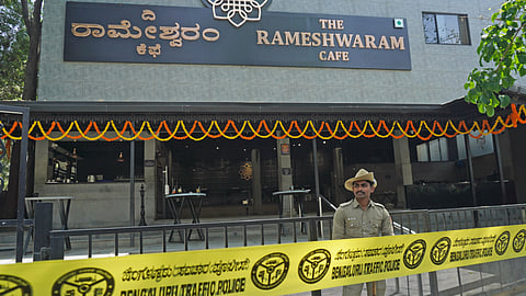 A Police personnel stand guard near the site of a bomb blast at Rameshwaram Cafe.