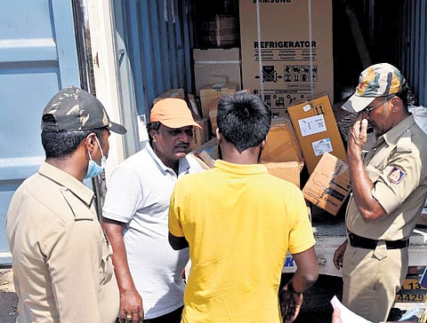 Police personnel on election duty inspect a vehicle at a checkpost in Magadi near Chikkamagaluru on Tuesday