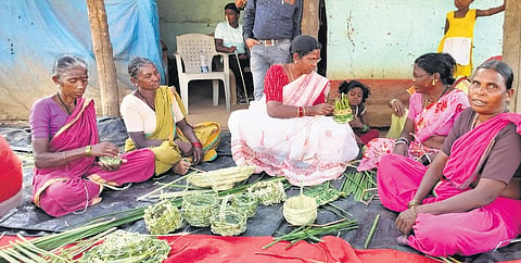 Women from the Kolam tribe learn how to weave baskets using cattail grass through DRDA project officer K Vijayalakshmi at Kolamguda village of Nirmal district.