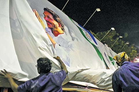 Workers removing banners of political parties in Vijayawada after the Model Code of Conduct came into force on Saturday