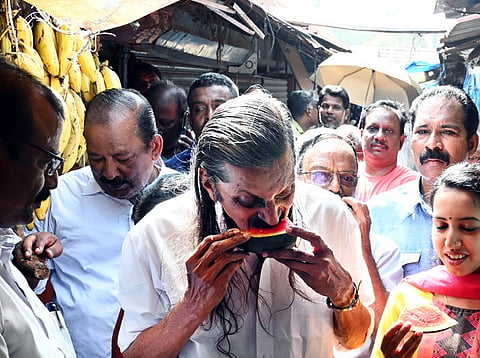 The LDF candidate in Thiruvananthapuram, Pannyan Raveendran trying to beat the heat by helping himself to a slice of water melon during his campaign on March 30, 2024.