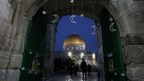 Muslims walk next to the Dome of Rock Mosque at the Al-Aqsa Mosque compound in Jerusalem's Old City.