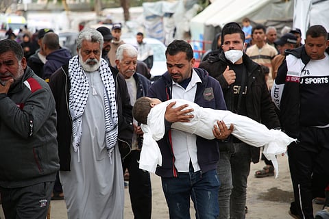 Mohsen Muammar carries the body of his son Muhammad, 3 years old, killed in the Israeli bombardment of the Gaza Strip, to his family house to bury him in Rafah, southern Gaza Strip, Friday, March 29, 2024.