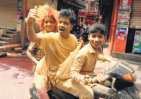 Kids on a scooter cheer during the celebrations