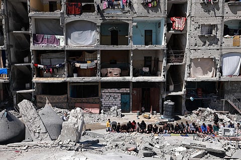 Palestinians perform the first Friday noon prayer of the Muslim holy fasting month of Ramadan over the ruins of Al-Farouq Mosque.