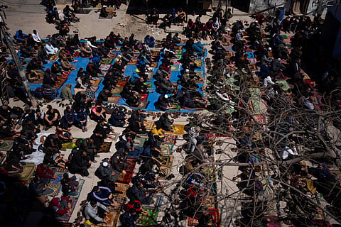 Palestinians perform the first Friday prayers of the Muslim holy month of Ramadan near the ruins of a destroyed mosque by the Israeli airstrikes in Rafah, Gaza Strip, Friday, March 15, 2024.