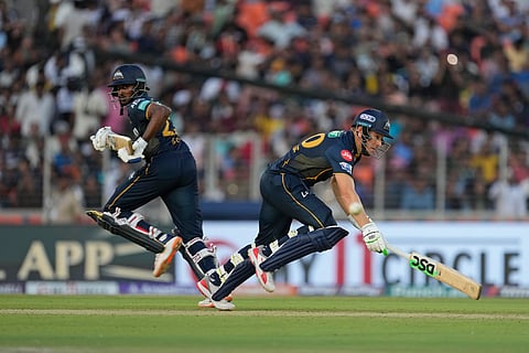 Gujarat Titans' Sai Sudharsan, left, and teammate David Miller run between the wickets during the Indian Premier League cricket match between Gujarat Titans and Sunrisers Hyderabad in Ahmedabad.