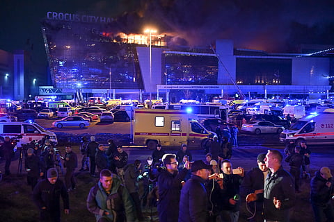 A man speaks to journalists as a massive blaze seen over the Crocus City Hall on the western edge of Moscow, Russia, Friday, March 22, 2024.