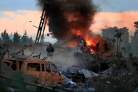 A man checks a destroyed warehouse, destroyed by an Israeli strike, at an industrial district in the southern coastal town of Ghazieh, Lebanon, Monday, Feb. 19, 2024.