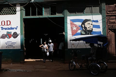 Shoppers exit a state-run agro-market, where a mural of Fidel Castro adorns the facade, in Havana, Cuba, Thursday, March 7, 2024.