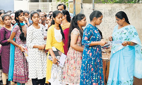 Teachers check hall tickets before students enter the examination hall in Karimnagar