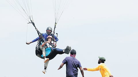 Philip Jose aka Appachan landing after paragliding at the adventure tourism park in Wagamon on Thursday