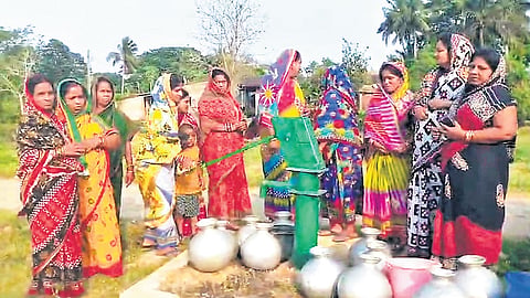 Women of Gamha village gather near a tube-well to collect water