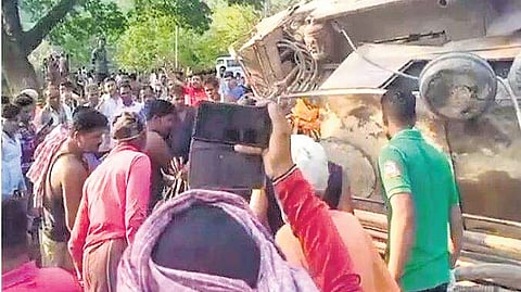 Locals gather near the overturned truck
