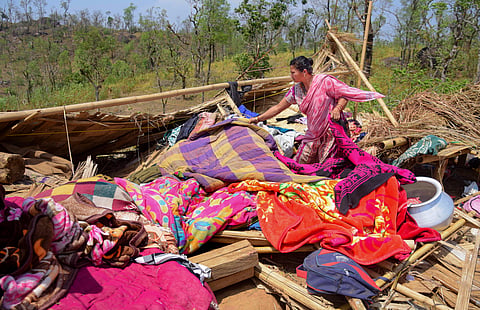 A woman attempts to salvage her belongings after her house was destroyed due to a hailstorm, at Boko in Kamrup district, Assam, Monday, April 1, 2024.