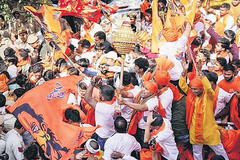 Security personnel attempt to control devotees during the procession