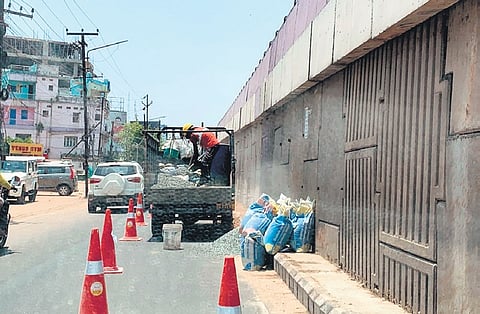 A worker unloads stone chips for road work at Palasuni on Friday
