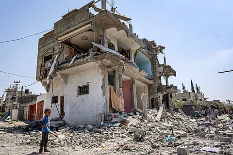 A boy stands by rubble before a heavily damaged building in the eastern side of the Maghazi camp for Palestinian refugees in the central Gaza Strip on April 15, 2024 amid the ongoing conlfict in the Palestinian territory between Israel and the militant group Hamas.