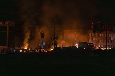 Rescue workers extinguish the fire at the site of a Russian drone attack in Kharkiv, Ukraine, early Saturday April 6, 2024.