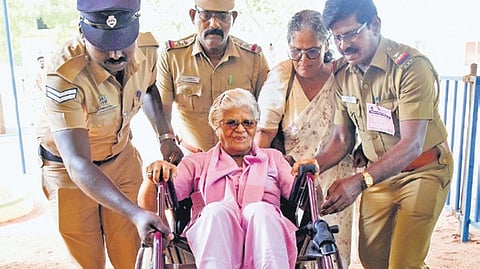 An elderly wheelchair user being taken to the booth by police officers in Tiruchy on Friday