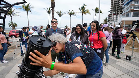An amateur astronomer prepares her telescope a day before a total solar eclipse in Mazatlan, Mexico on Sunday.
