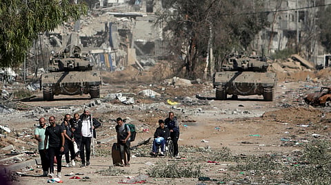 Palestinians flee from northern Gaza as Israeli tanks block the Salah al-Din road in the central Gaza Strip.