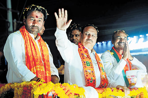 BJP state chief G Kishan Reddy looks on as party president JP Nadda waves to the crowd during a roadshow in Nizampet.