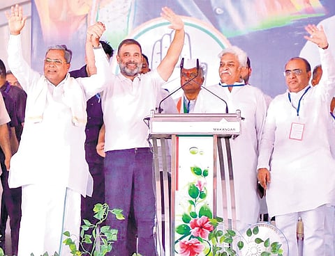 Congress leader Rahul Gandhi and Chief Minister Siddaramaiah greet the gathering at a rally in Vijayapura on Friday