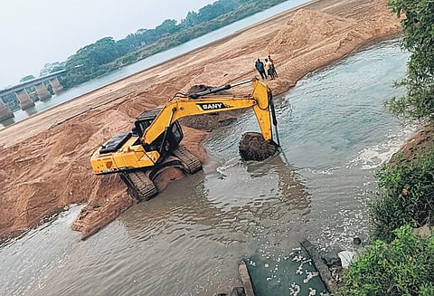 An earthmover engaged in dredging Luna riverbed at Kalapada