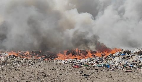 Smoke from dump yard engulfing nearby road, completely obstructing the vision