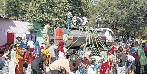 People collect drinking water from a tanker at Vivekanand camp on Tuesday.