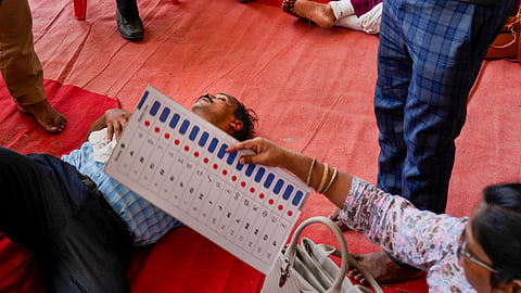 A polling official faints at a distribution center amid heatwave, on the eve of the seventh and last phase of the Lok Sabha elections.