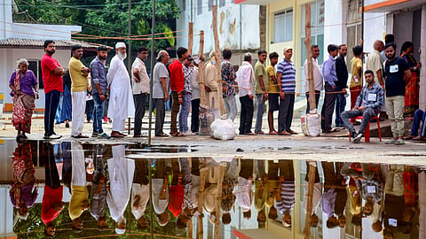 People wait to cast their vote for 4th phase of Lok Sabha elections, in Lakhimpur Kheri.