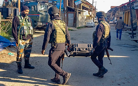 Security personnel stand guard after an encounter at Redwani area, in Kulgam district, Tuesday, May 7, 2024.
